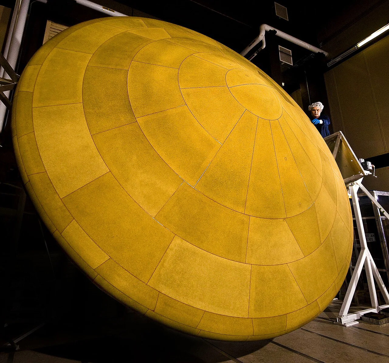 NASA'nın Mars Bilim Laboratuvarı için üretilen 4,5 metre çapındaki ısı kalkanı, montaj salonunda bir çalışanın yanında