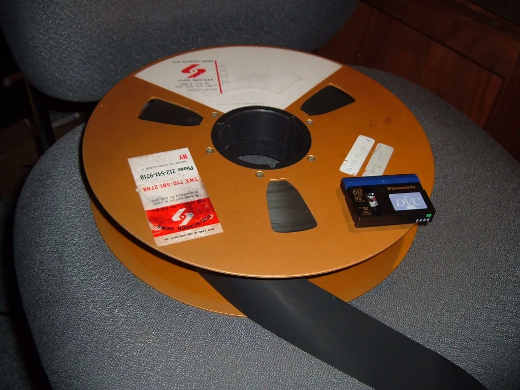 2 inçlik quadruplex video bandı makarası, yanında bir miniDV kaseti
