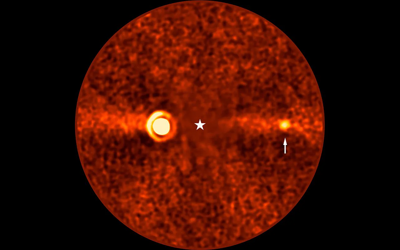 ESO'nun VLT görüntüsünde Beta Pictoris d (okla gösterilen) ve solda parlak Beta Pictoris b; yatay bant kenarından görülen enkaz diski